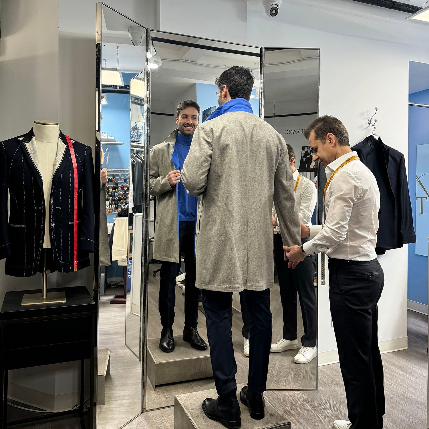 Aziz assisting a man who is testing a Lecce Coat