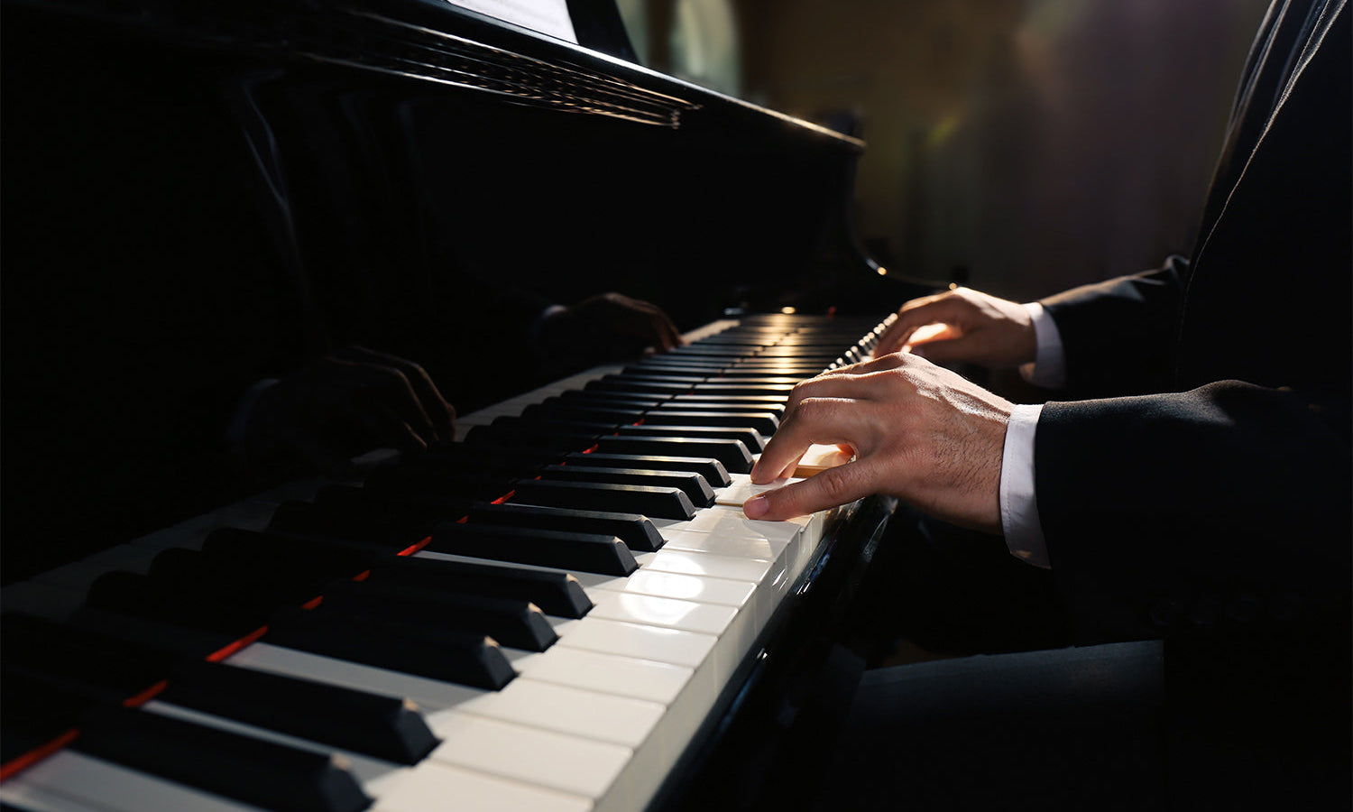 Man playing piano indoors, closeup.