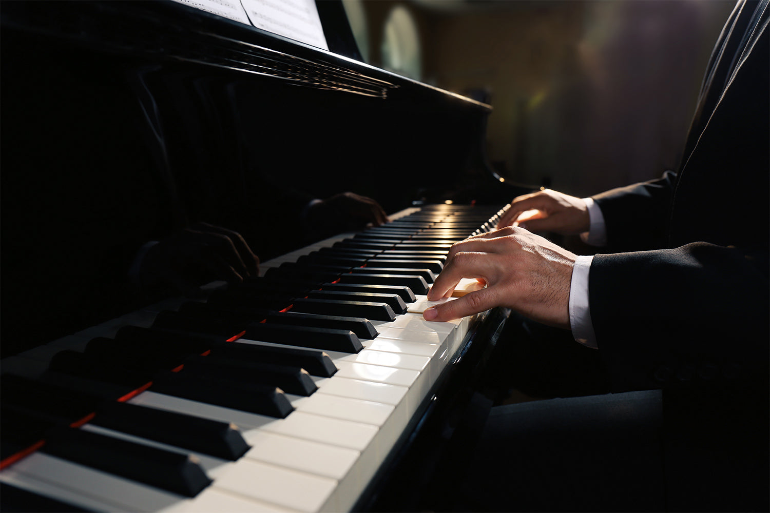 Man playing piano indoors, closeup.